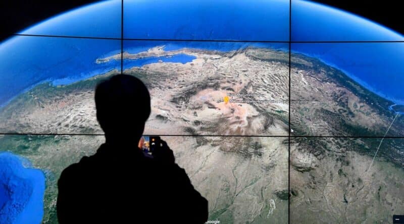 Un homme regarde une carte Google Earth sur un écran alors que Google Earth dévoile la version remaniée de l’application le 18 avril 2017 lors d’un événement au Whitney Museum of Art de New York. 